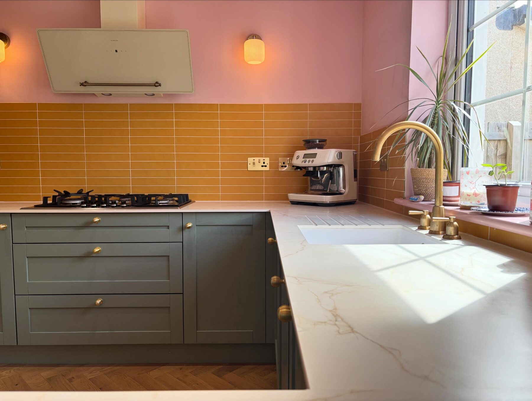 Grey shaker kitchen with yellow tiled splashback and marble worktop