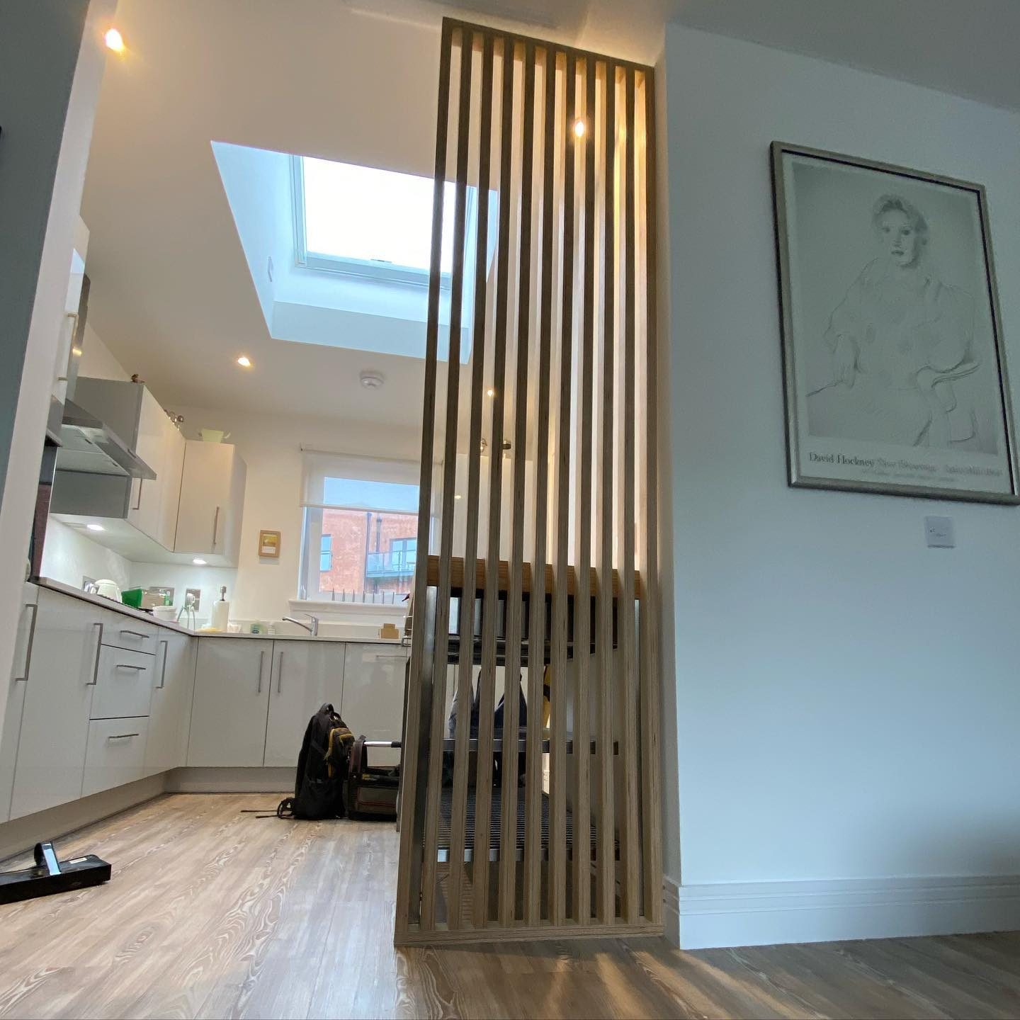 Slatted timber room divider and fitted storage unit